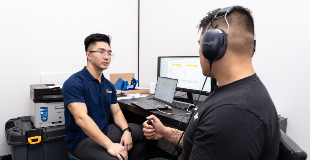 A trained professional from AusRehab is performing workplace hearing test for a worker.