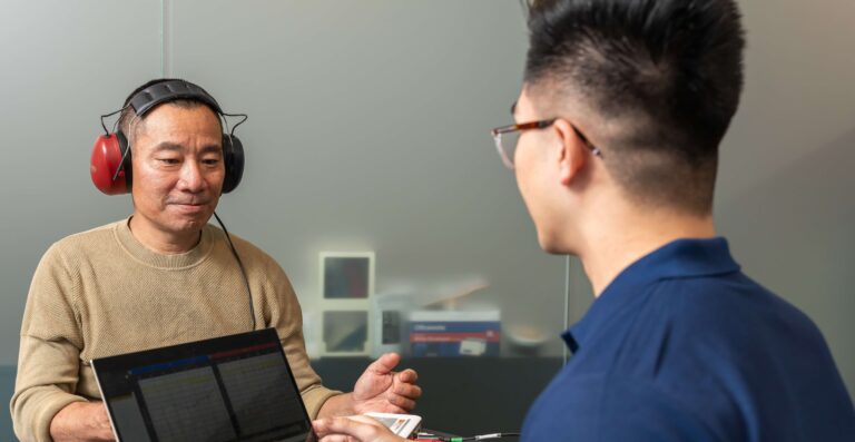 A health professional is performing workplace hearing test on a worker.